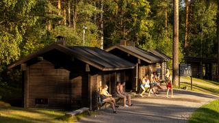 Saunojia Kuusijärven pienten savusaunojen edessä