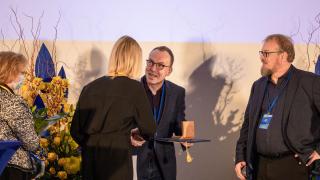 Vantaan kaupunginhallituksen puheenjohtaja Sari Multala luovuttaa Vantaa-mitalin Minttiravintoloiden Kimmo Bergmanille.