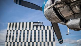 Korkean hotellirakennuksen edustalla mallilentokone.