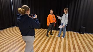 Hackathoniin osallistuvat oppilaat haastattelevat opettajaa.