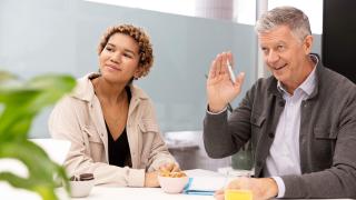 Woman and man are discussing something at the table.
