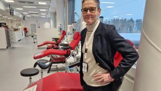 Johanna Castrén seisoo Veripalvelun uudessa verenluovutuspisteessä Vantaalla punaisten verenluovutustuolien edessä.