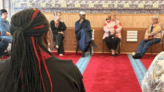 Myyrmäen moskeijan imaami Aw-Musse  Said Sharmarke keskustelemassa Wahvat naiset -verkoston jäsenten kanssa moskeijasalissa.