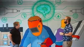 Kaksi ihmistä ihailee seinämaalausta.