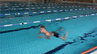 ihminen ui uimahallissa.