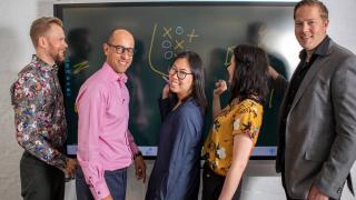 ihmiset piirtävät taululla.