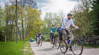 ihmiset pyöräilevät puistossa.