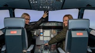 Kaksi ihmistä lentosimulaattorissa.