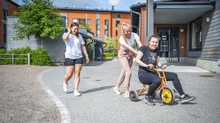 Kolme lastenhoitajaa päiväkodin pihalla.