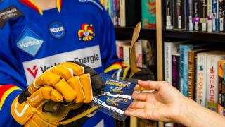 nuori henkilö ottaa kaksi kausikorttia käsiin.