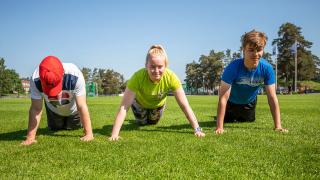 Nuoria jumppaamassa puistossa.