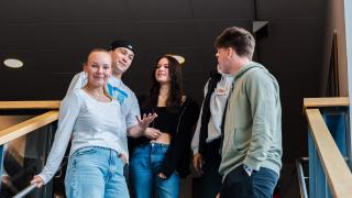 Oppilaat seisovat portaissa.