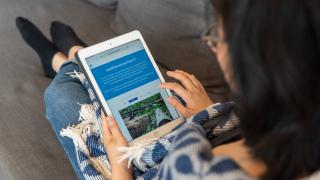 Aikuinen selaa tabletilla Osallistuvavantaa.fi-sivua.