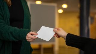 handing out a ballot paper.
