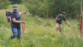 Ihmisiä niittytalkoissa Vehkalanmäellä. 
