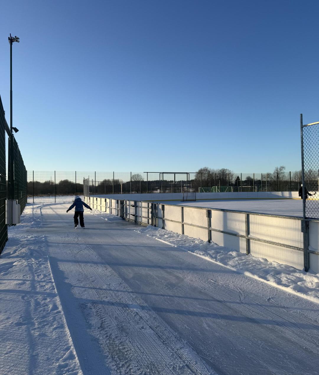 Kartanonkosken tekojääkentällä lapsi luistelemassa.