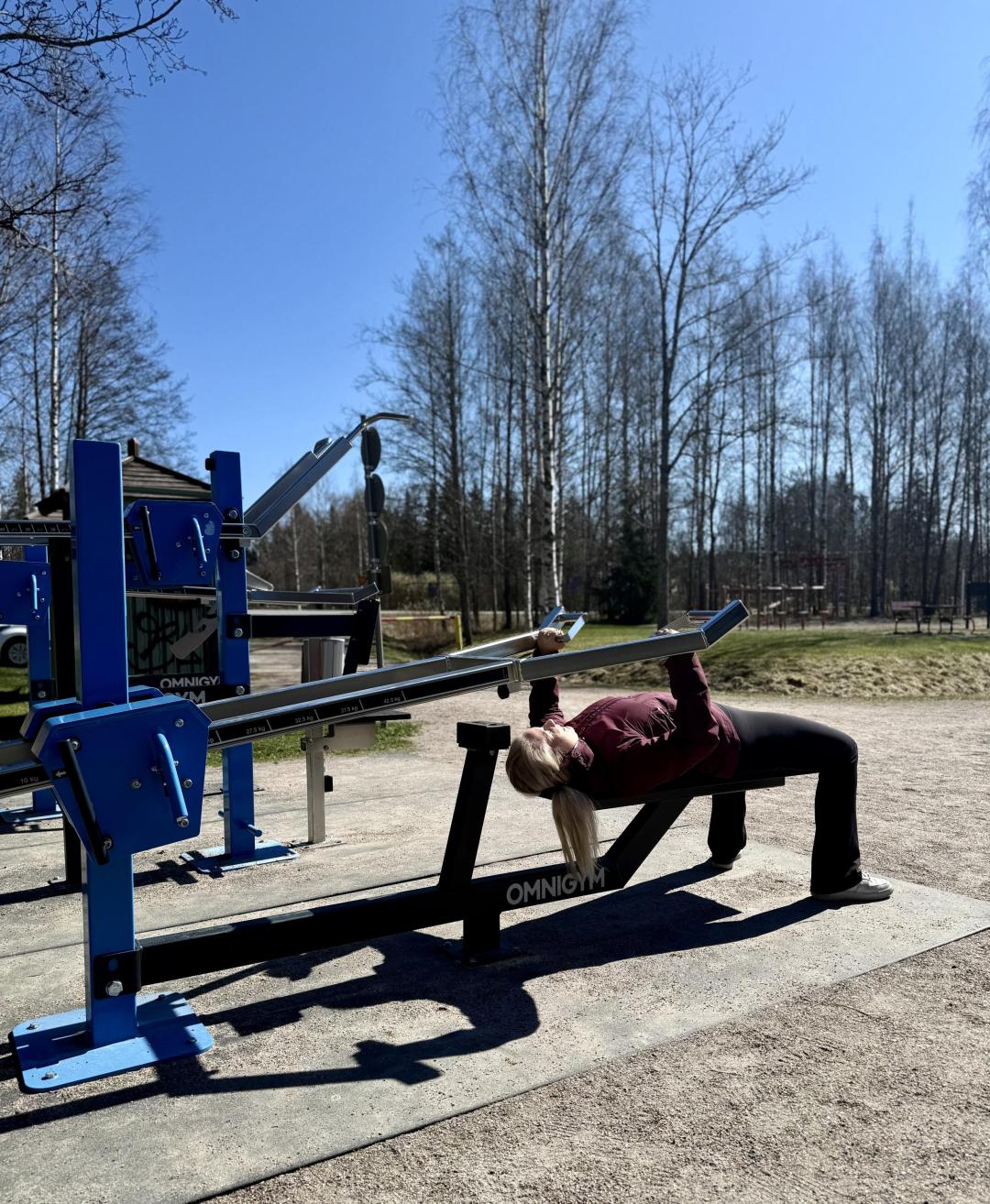 Nikinmäen uimapaikan ulkokuntosalilla kuntoilija tekee penkkipunnerrusta.