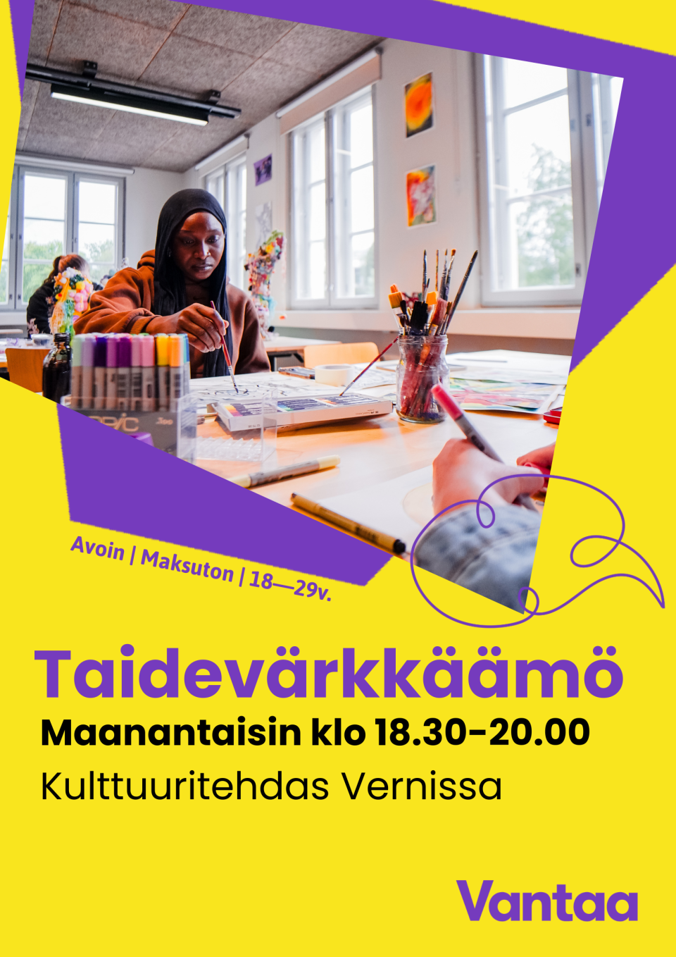 nuori aikuinen taiteilee pöydän ääressä.