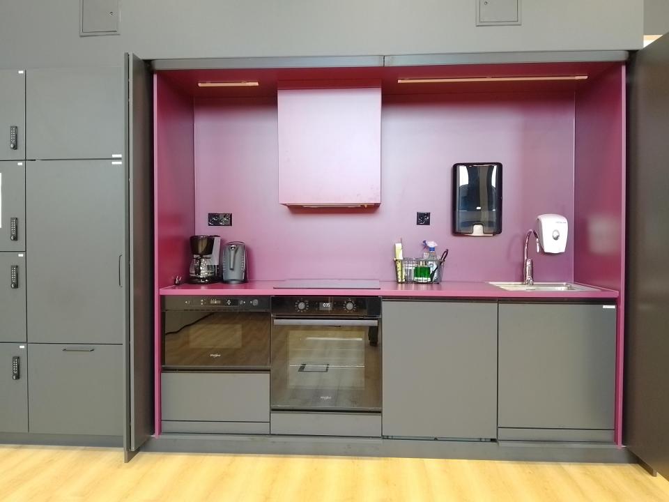 Tumma keittiösyvennys, jossa uuni ja vesipiste.