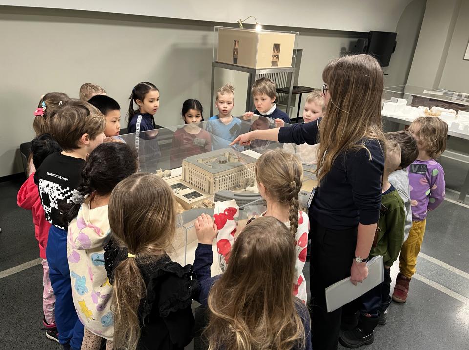 Eskarilaiset tutkivat Eduskuntatalon pienoismallia.