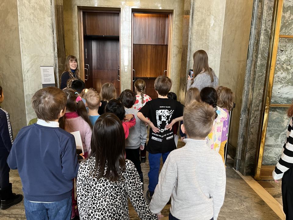 Eskarilaiset ihailevat Eduskuntatalon pater noster -hissiä.