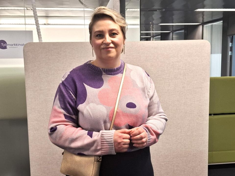 Kuvassa Salla Rajala. Hänellä on päällä kukkapaita ja olalla laukku.