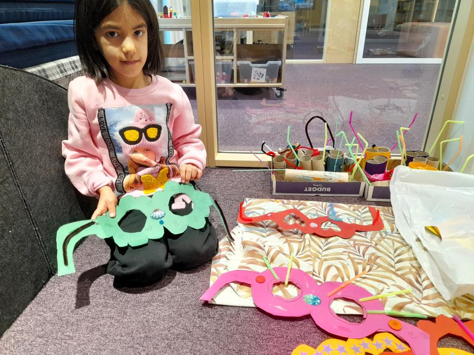 Eskarilainen esittelee kartonginsta askartelemiaan lapsilaseja.