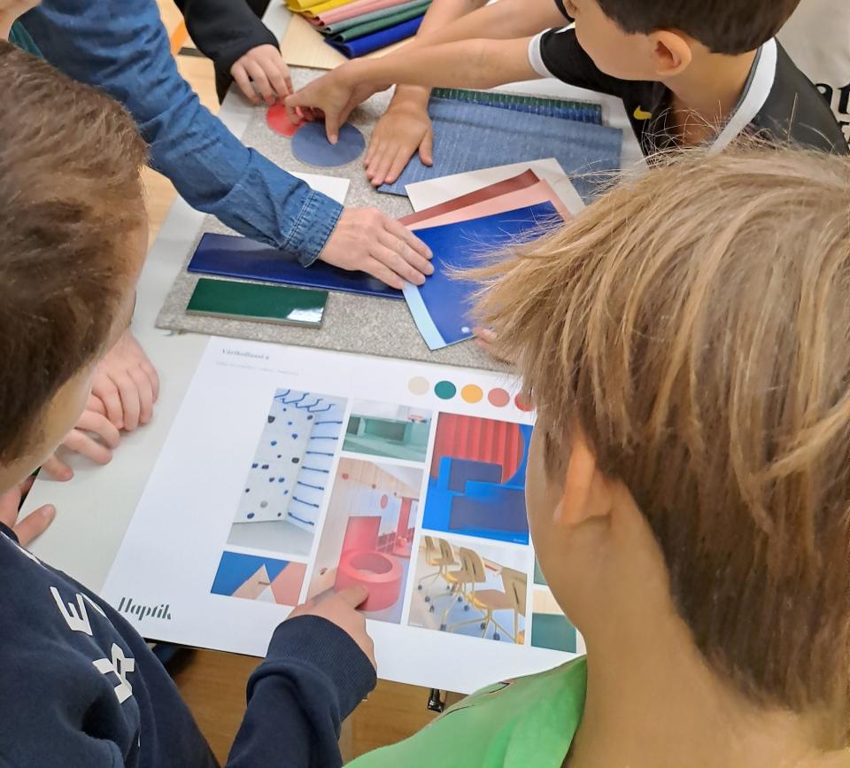 Lapset katsomassa erilaisia sisätilojen kuvia.