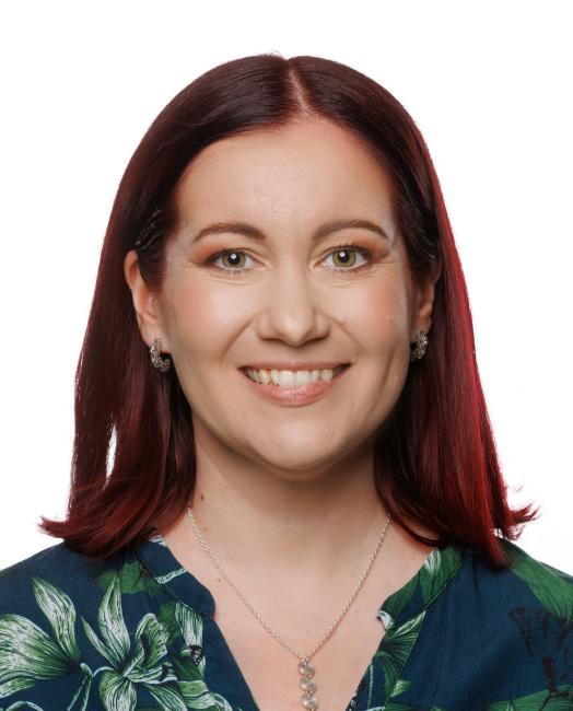 Nainen jolla on punaruskeat hiukset ja vihreä vaate.